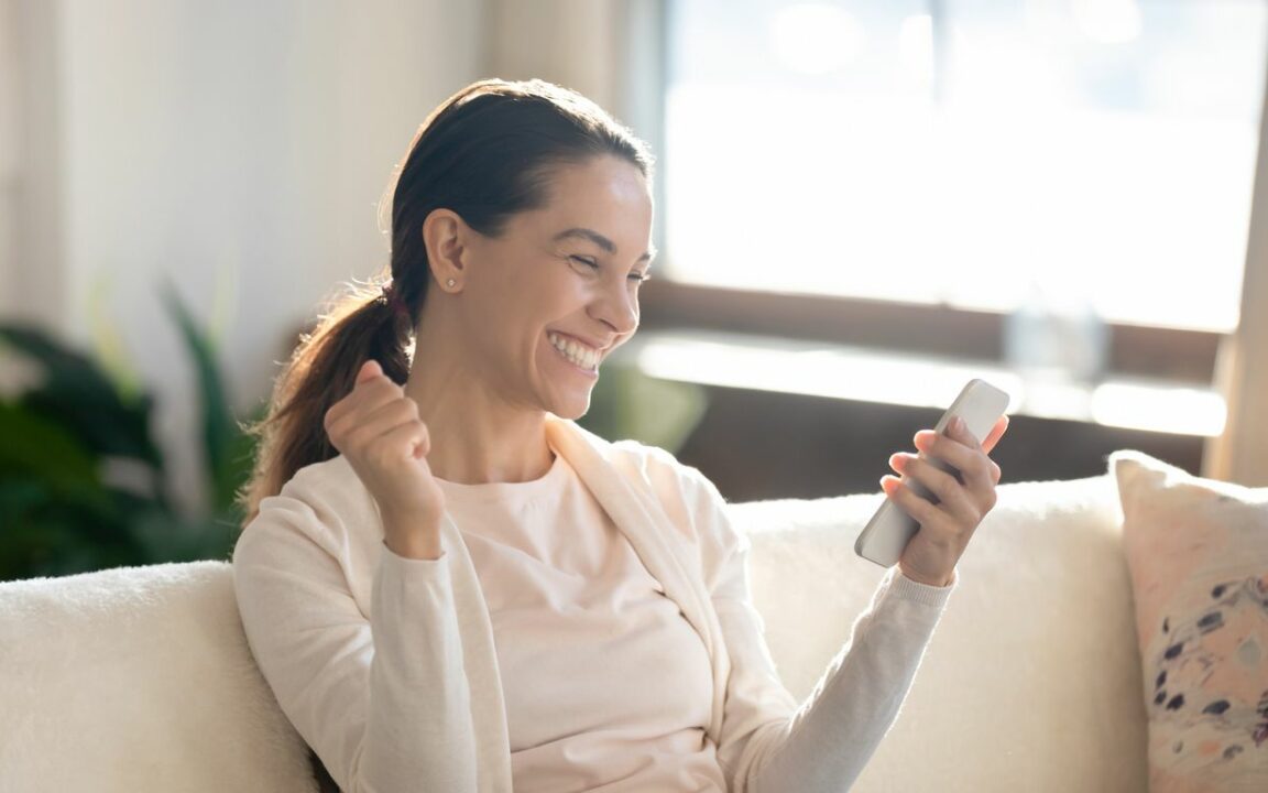 woman smiling at e-gift card she received on her phone