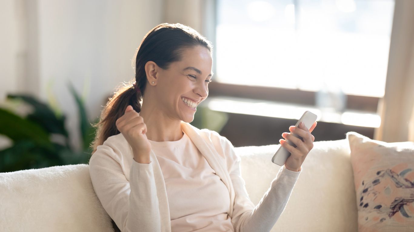woman smiling at e-gift card she received on her phone